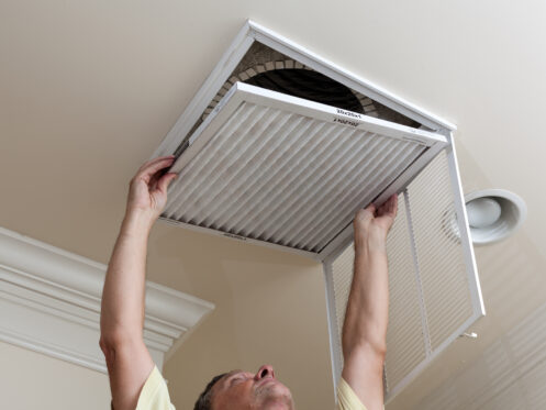 Man replacing air filter in air conditioning unit